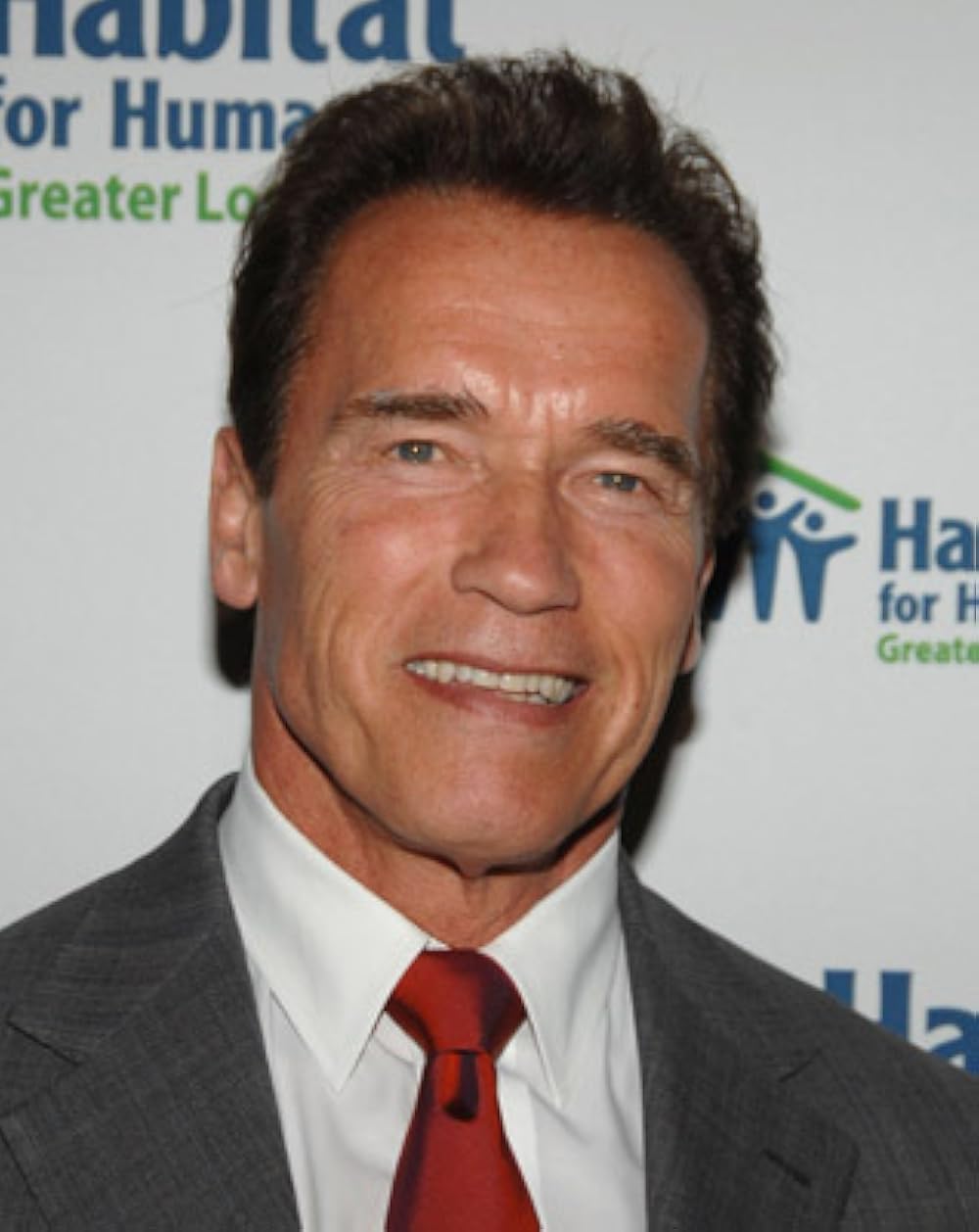 Portrait of Arnold Schwarzenegger in a suit and red tie