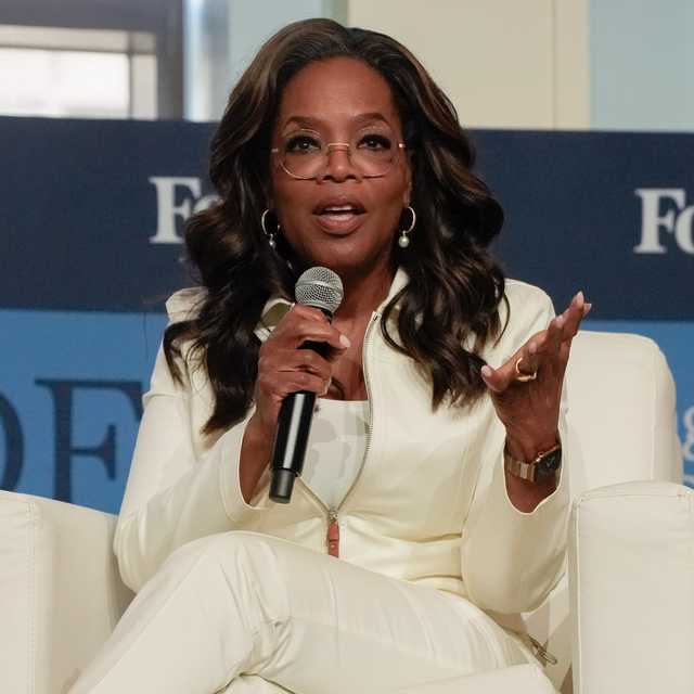 A television host speaking on stage at a conference
